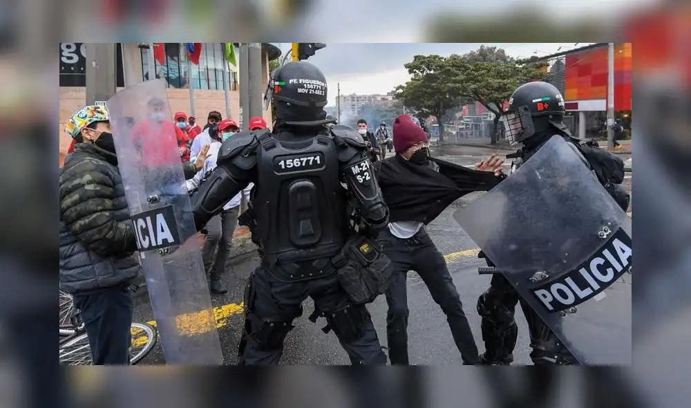 Policías jalonean a manifestantes durante las protestas en Colombia. Se han registrado cerca de mil detenciones arbitrarias. Foto AFP.