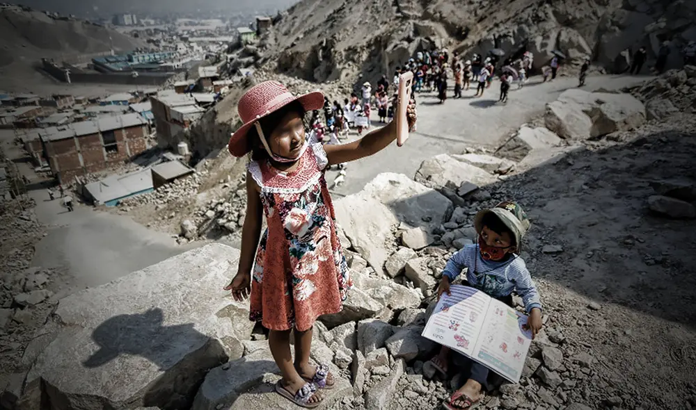 Dos hermanitos intentan captar señal para poder acceder a sus clases virtuales. Foto: Antonio Melgarejo / La República