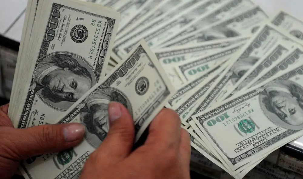 El precio del dólar oficial es chequeado tanto por compradores como por comerciantes. Foto: AFP