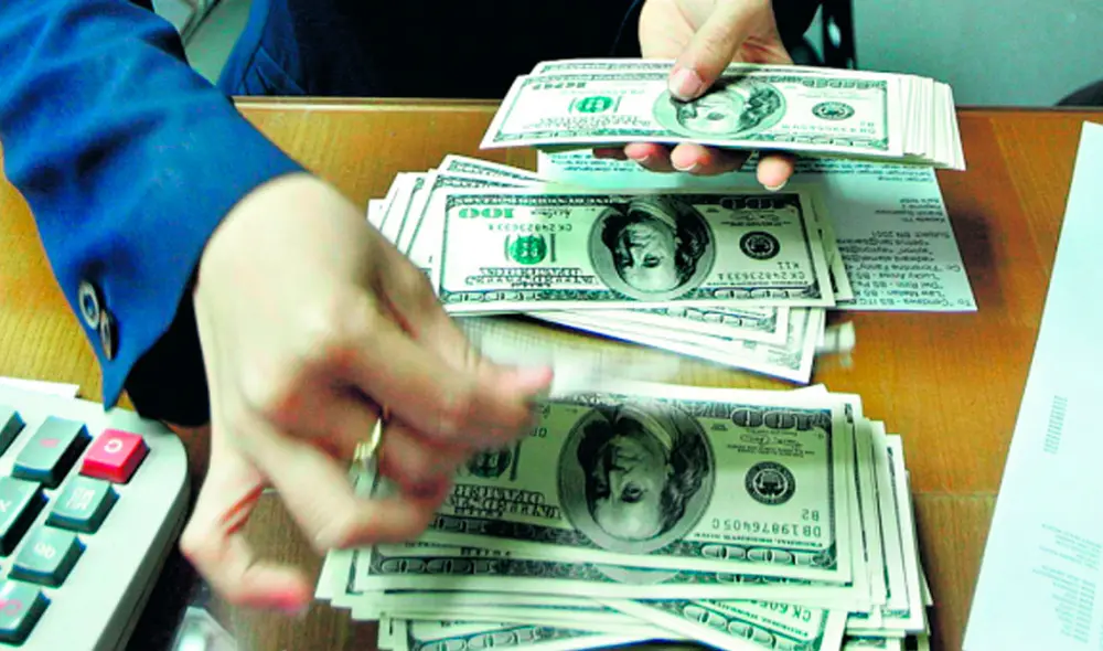 El precio del dólar oficial es chequeado tanto por compradores como por comerciantes. Foto: AFP El precio del dólar oficial es chequeado tanto por compradores como por comerciantes. Foto: AFP