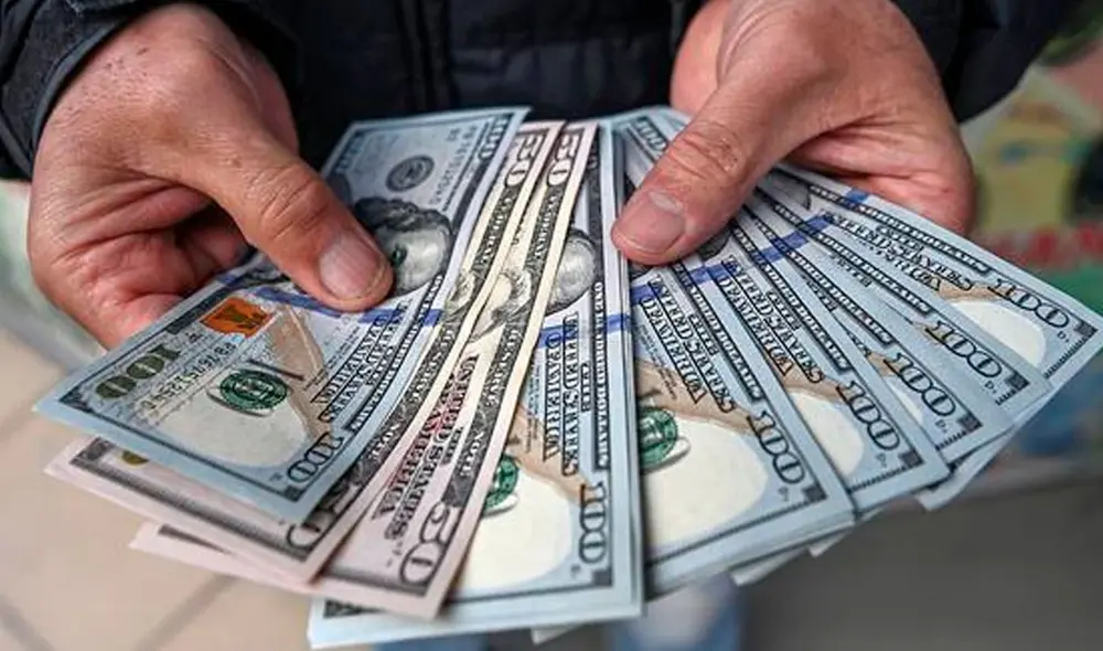 El precio del dólar oficial es chequeado tanto por compradores como por comerciantes. Foto: AFP El precio del dólar oficial es chequeado tanto por compradores como por comerciantes. Foto: AFP