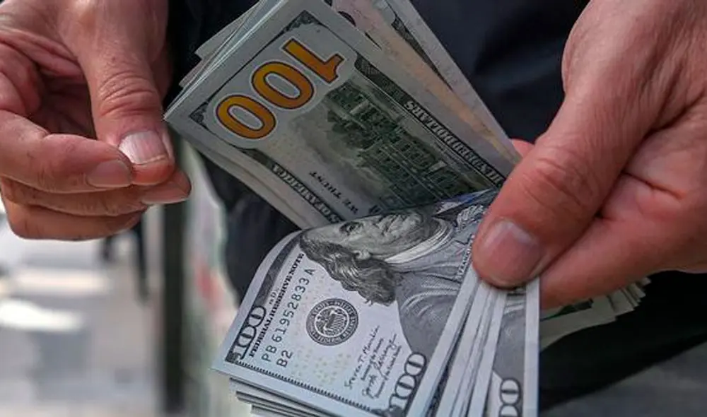 El precio del dólar oficial es chequeado tanto por compradores como por comerciantes. Foto: AFP El precio del dólar oficial es chequeado tanto por compradores como por comerciantes. Foto: AFP