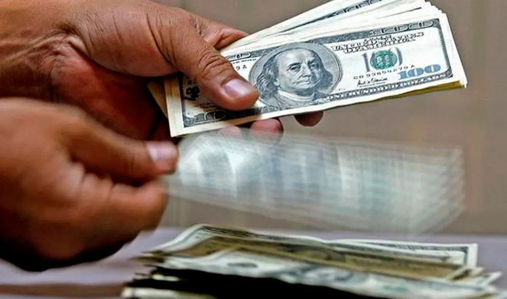 El precio del dólar oficial es chequeado tanto por compradores como por comerciantes. Foto: AFP El precio del dólar oficial es chequeado tanto por compradores como por comerciantes. Foto: AFP