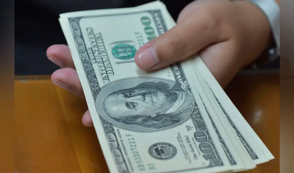 El precio del dólar oficial es revisado tanto por compradores como por comerciantes. Foto: AFP