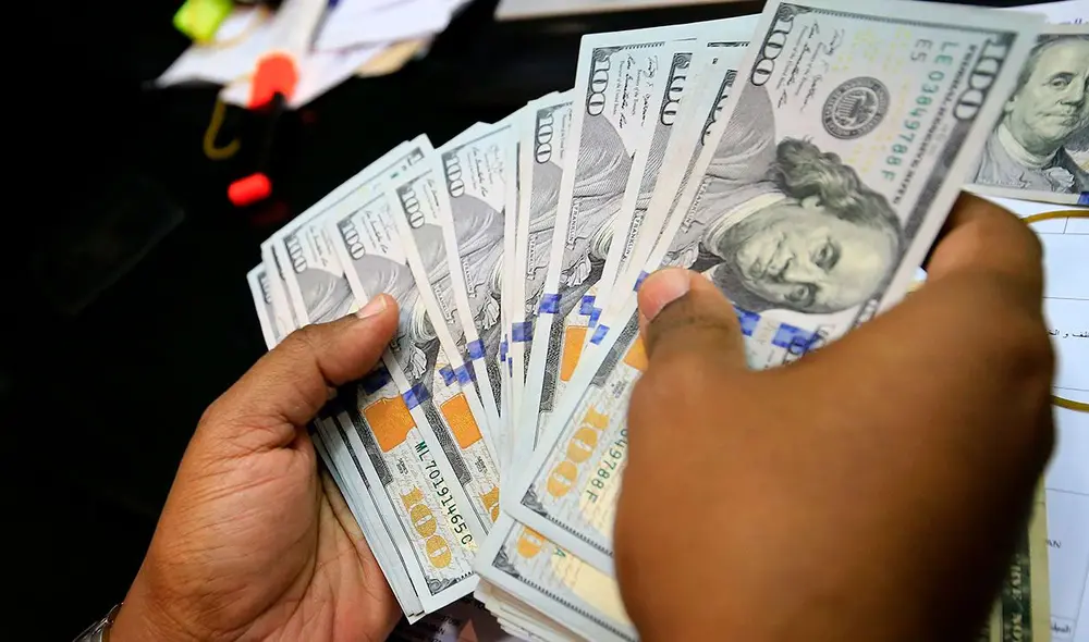 El precio del dólar oficial es revisado tanto por compradores como por comerciantes. Foto: AFP El precio del dólar oficial es revisado tanto por compradores como por comerciantes. Foto: AFP