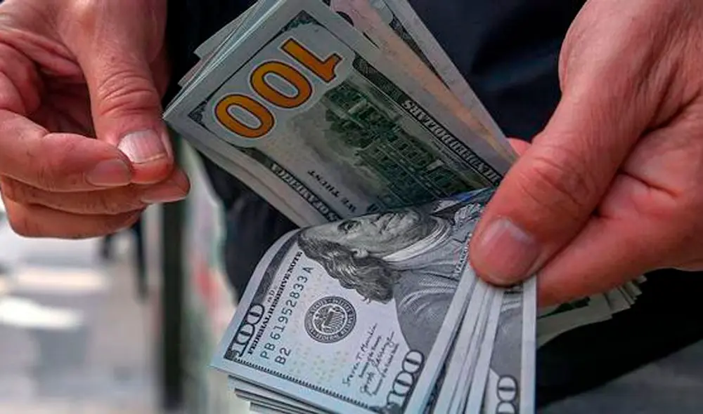 El precio del dólar oficial es revisado tanto por compradores como por comerciantes. Foto: AFP