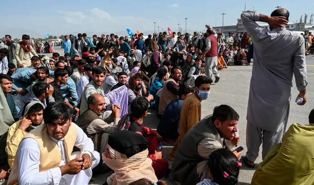 Cientos de personas esperan en las instalaciones del aeropuerto de Kabul por algún avión que los lleve fuera de Afganistán. Foto: AFP Cientos de personas esperan en las instalaciones del aeropuerto de Kabul por algún avión que los lleve fuera de Afganistán. Foto: AFP