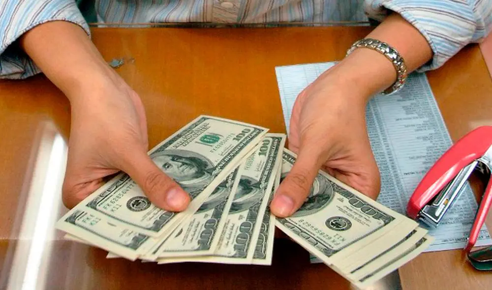 El precio del dólar oficial es revisado tanto por compradores como por comerciantes en Venezuela. Foto: AFP El precio del dólar oficial es revisado tanto por compradores como por comerciantes en Venezuela. Foto: AFP