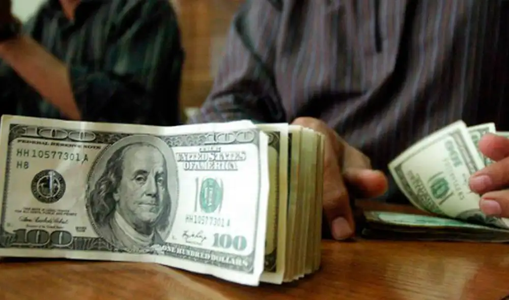 El precio del dólar oficial es revisado tanto por compradores como por comerciantes en Venezuela. Foto: AFP El precio del dólar oficial es revisado tanto por compradores como por comerciantes en Venezuela. Foto: AFP