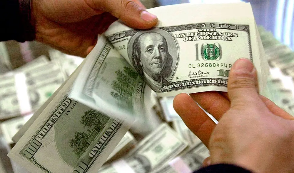 El precio del dólar oficial es revisado tanto por compradores como por comerciantes en Venezuela. Foto: AFP El precio del dólar oficial es revisado tanto por compradores como por comerciantes en Venezuela. Foto: AFP