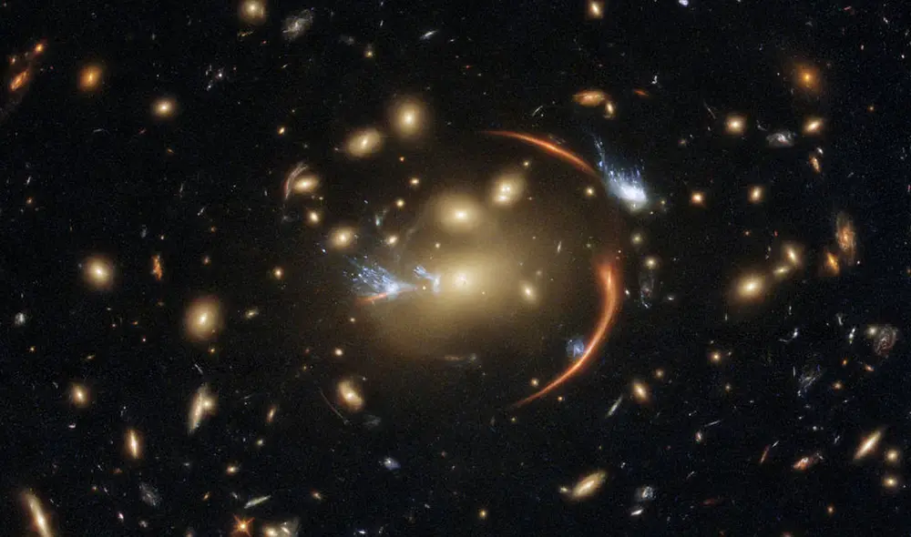 Vista del cúmulo de galaxias cuya gravedad distorsiona la luz de los objetos más lejanos. Foto: Hubble/ ESA/ NASA