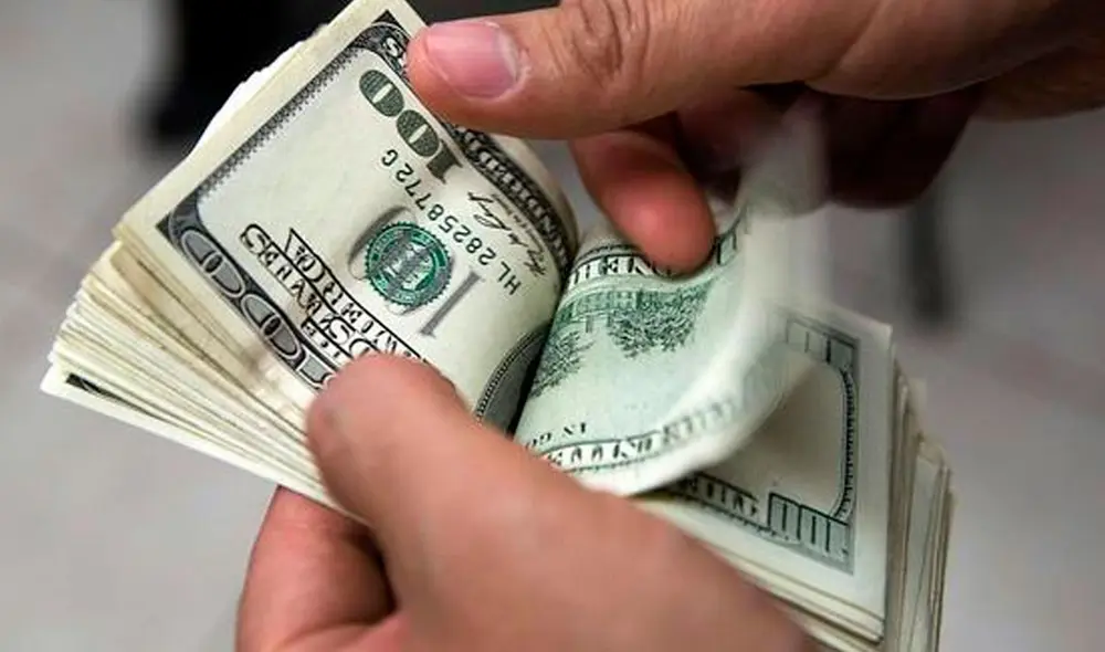 El precio del dólar oficial es revisado tanto por compradores como por comerciantes en Venezuela. Foto: AFP