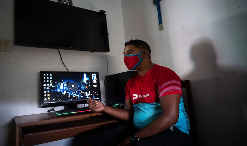Zacary Egea también trabaja como repartidor de una aplicación de entrega a domicilio en Venezuela. Foto: AFP