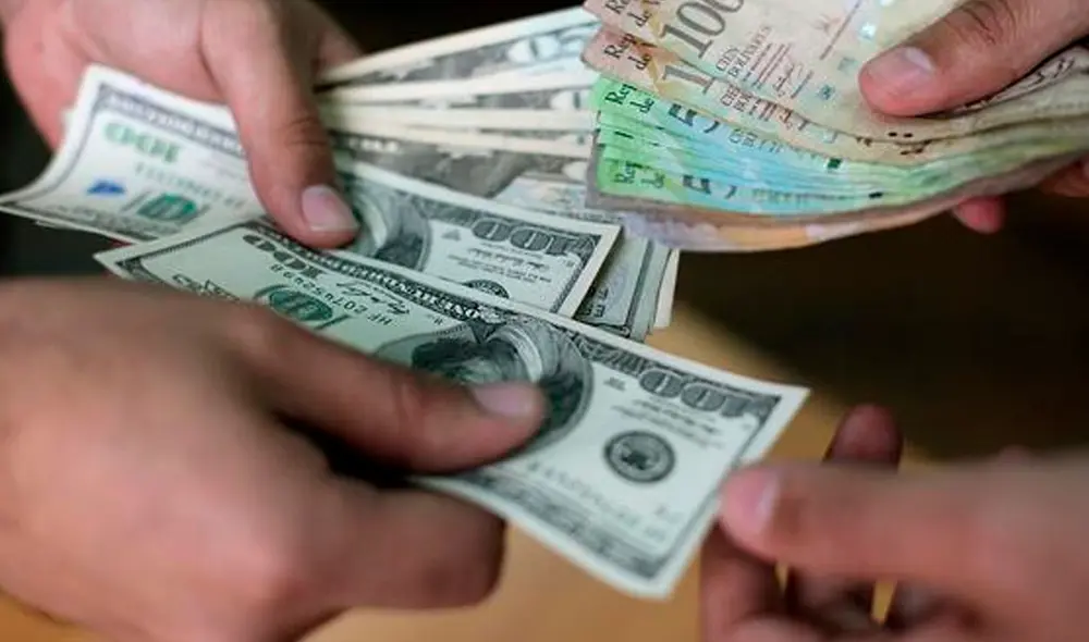 El precio del dólar oficial es revisado tanto por compradores como por comerciantes en Venezuela. Foto: AFP El precio del dólar oficial es revisado tanto por compradores como por comerciantes en Venezuela. Foto: AFP