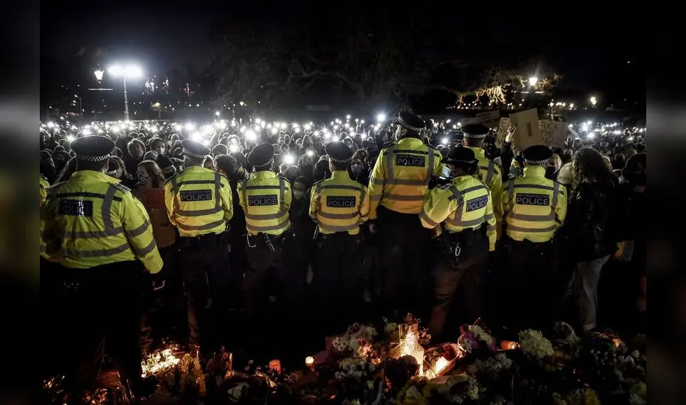 Las linternas de los teléfonos brillan en señal de protesta mientras los agentes de policía hacen guardia durante la vigilia en Londres. Foto: New York Times