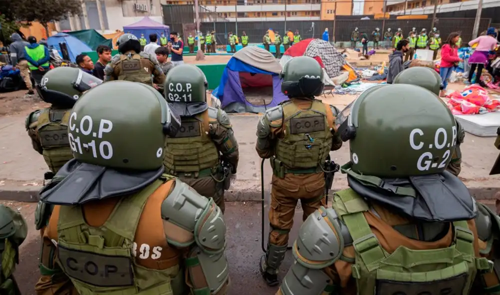 El desalojo en la Plaza Brasil, en Iquique, derivó en violencia y terminó con cinco personas detenidas y una carabinera herida. Foto: EFE