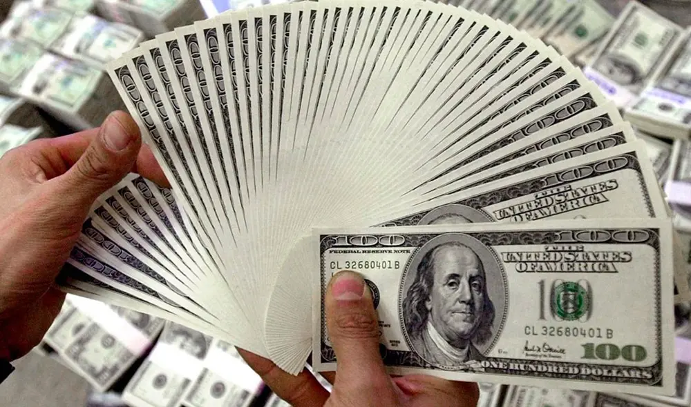 Compradores y vendedores chequean con asiduidad el dólar BCV en Venezuela. Foto: AFP