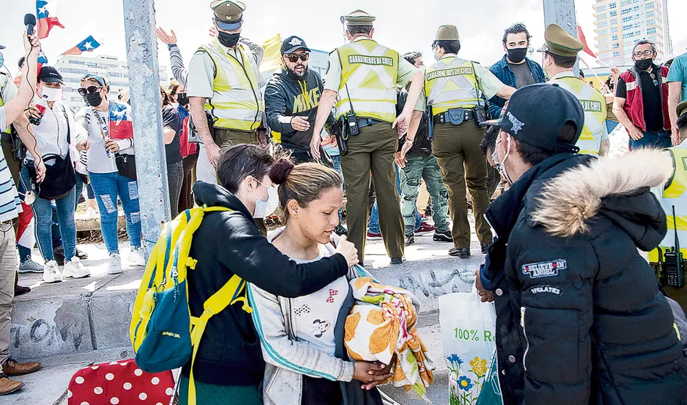 Vulnerables. Los migrantes venezolanos son asediados por manifestantes durante una marcha de antiinmigrantes en Iquique. Foto: AFP