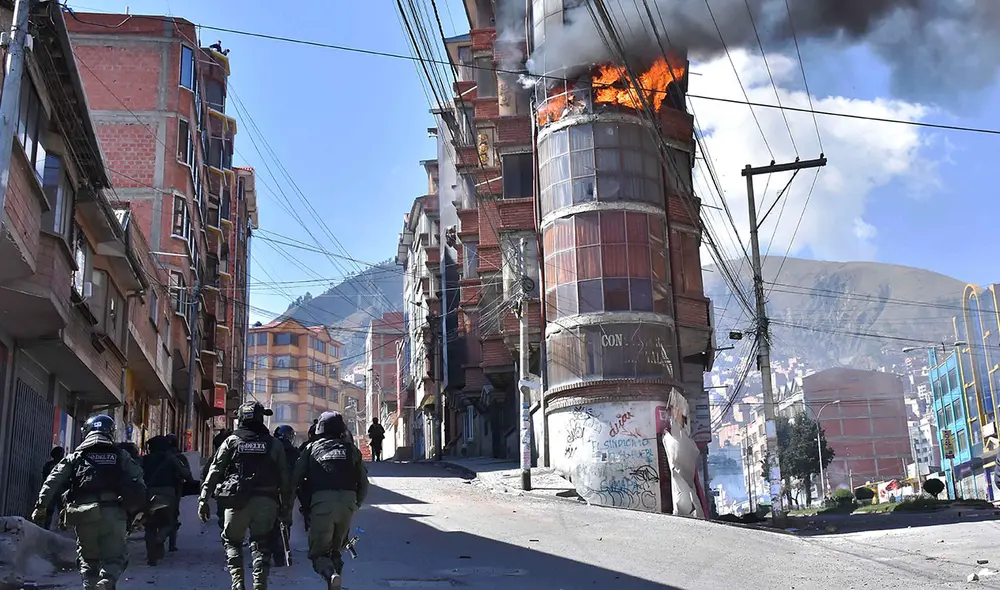 Policías antidisturbios se dirigen hacia un edificio donde se registra un incendio en medio de un enfrentamiento entre cocaleros y agentes. Foto: EFE Policías antidisturbios se dirigen hacia un edificio donde se registra un incendio en medio de un enfrentamiento entre cocaleros y agentes. Foto: EFE