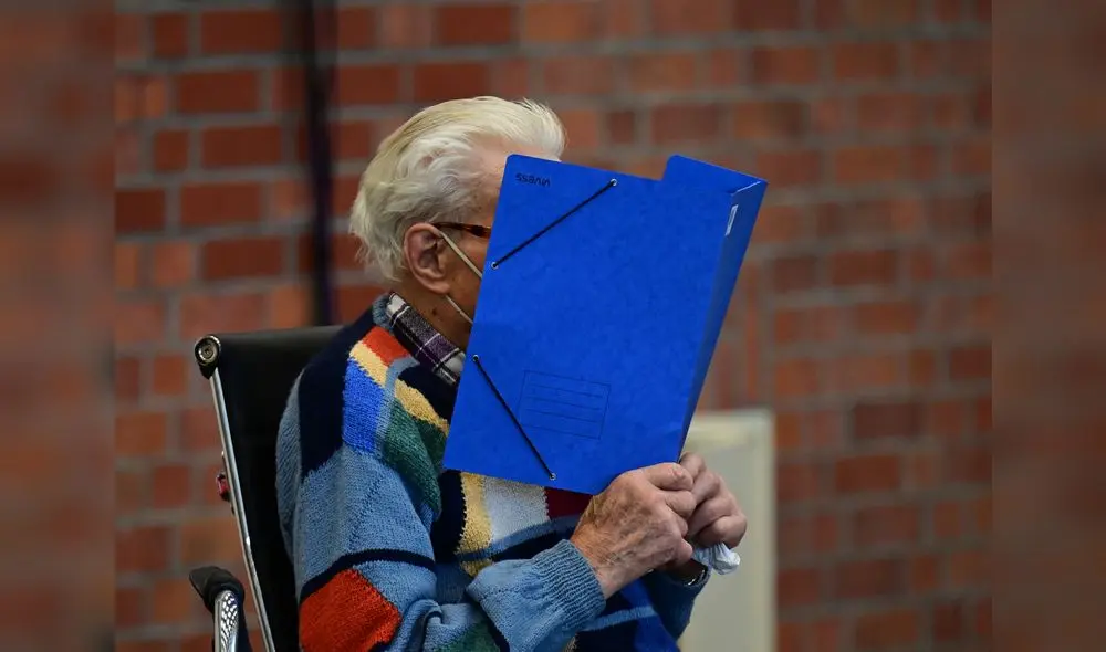 El acusado esconde su rostro detrás de una carpeta cuando llega para su juicio en Brandenburg an der Havel, en el noreste de Alemania, el 7 de octubre de 2021. Foto: Tobias Schwarz/AFP