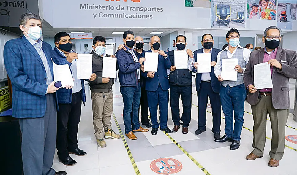 Sin un rumbo. El ministro Juan Silva se reunió con transportistas con serios antecedentes. En la foto sale cogiendo un acta con el dueño de la empresa Orión. Foto: difusión