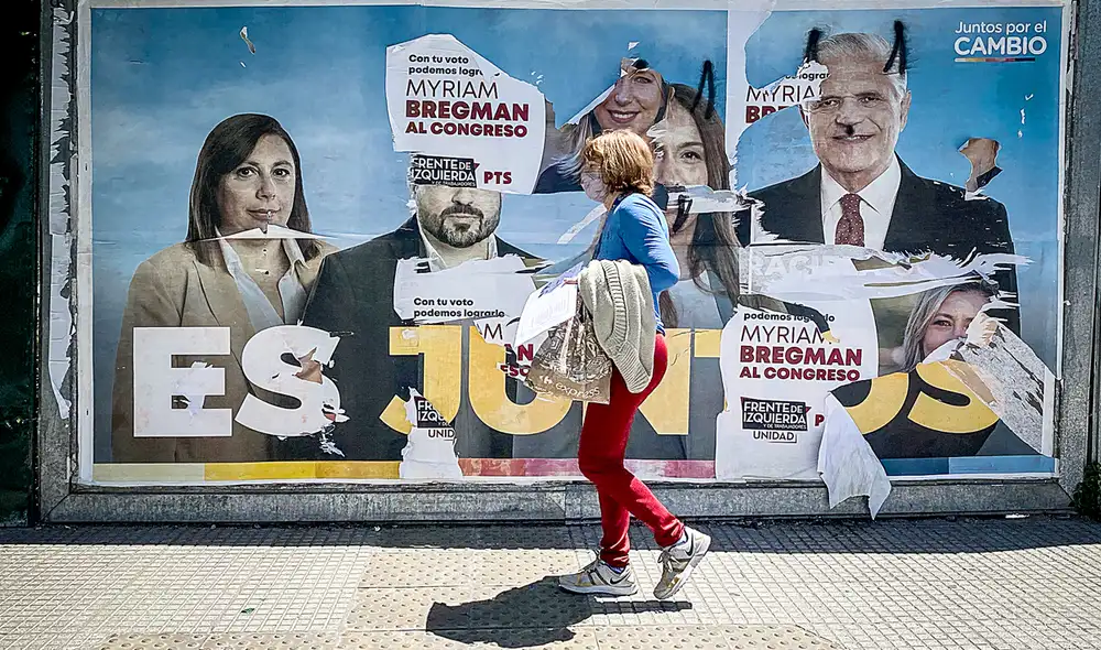 Domingo 14 de noviembre. Una mujer camina frente a un cartel alusivo a la coalición política Juntos por el Cambio, en Buenos Aires. Foto: EFE Domingo 14 de noviembre. Una mujer camina frente a un cartel alusivo a la coalición política Juntos por el Cambio, en Buenos Aires. Foto: EFE