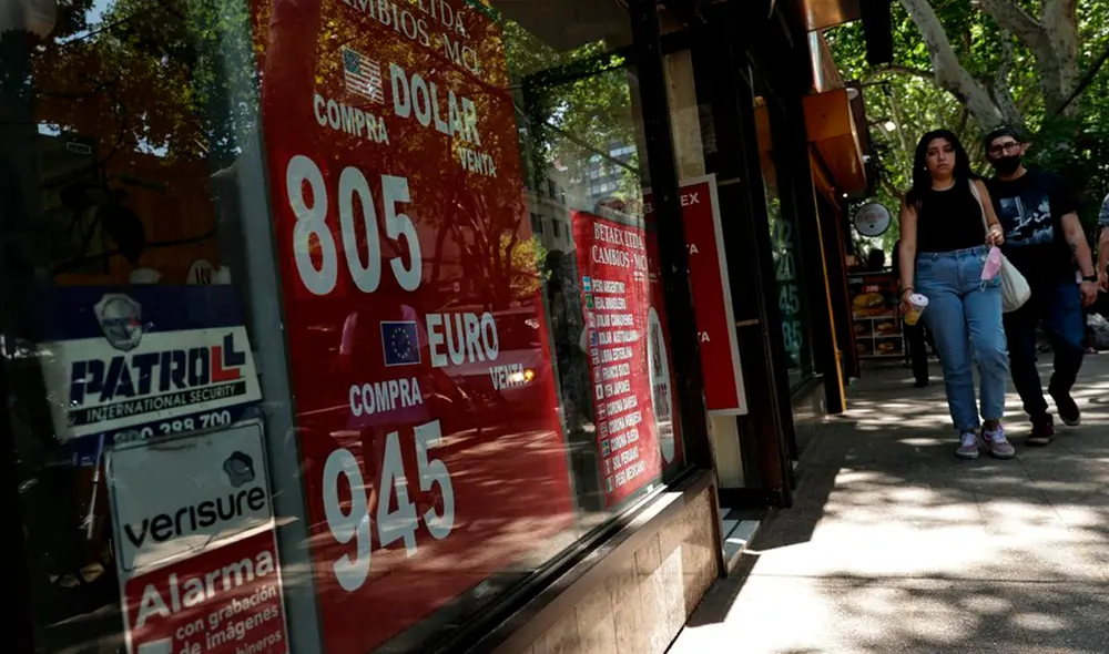Dos personas caminan junto a una casa de cambio el 12 de noviembre de 2021 en Santiago de Chile. Foto: EFE