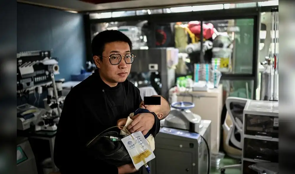 La foto tomada el 21 de octubre de 2021 muestra a Xu Wei sosteniendo a su hijo Xu Haoyang, diagnosticado con síndrome de Menkes. Foto: AFP