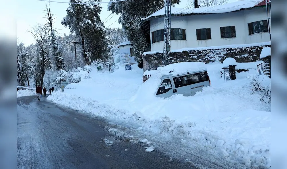 El vehículo de los turistas está varado en una carretera cubierta de nieve en una zona afectada por fuertes nevadas en Murree, Pakistán. Foto: EFE