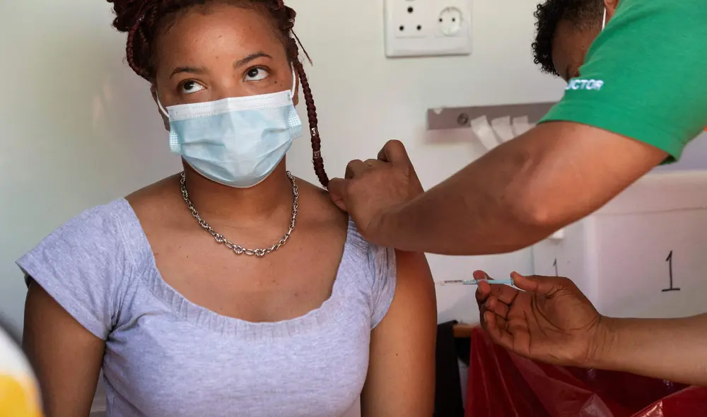 Una mujer se vacuna contra la COVID-19 en un centro médico instalado en Ciudad del Cabo (Sudáfrica), el 8 de diciembre. Foto: Rodger Bosch / AFP