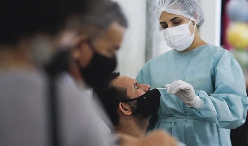 A un hombre le hacen una prueba de hisopado de COVID-19 en la estación de autobuses urbanos, en el centro de Brasilia, Brasil. Foto: AFP