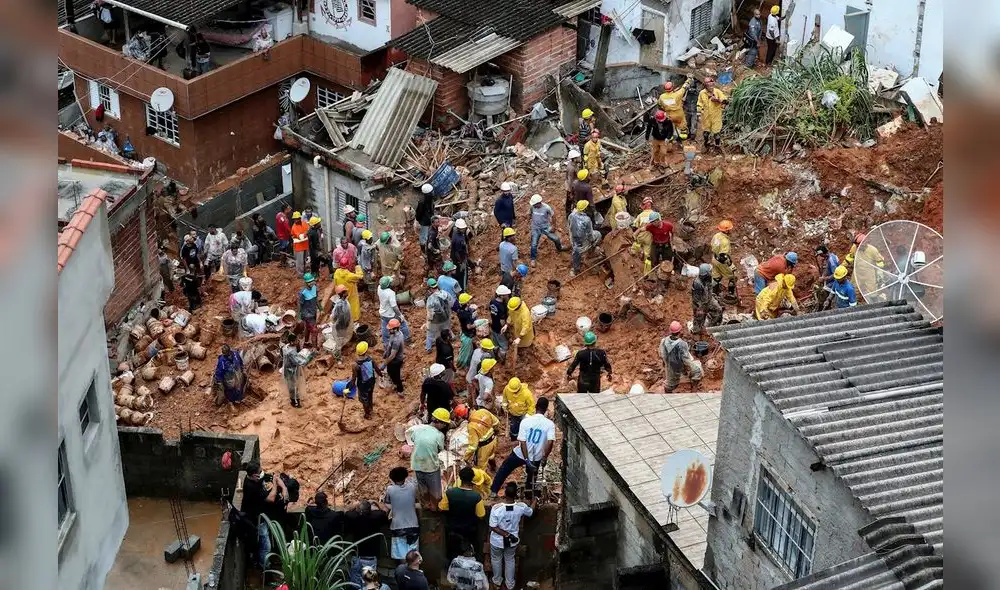 Bomberos y voluntarios trabajan en el área de un deslizamiento de tierra provocado por fuertes lluvias. Foto: EFE