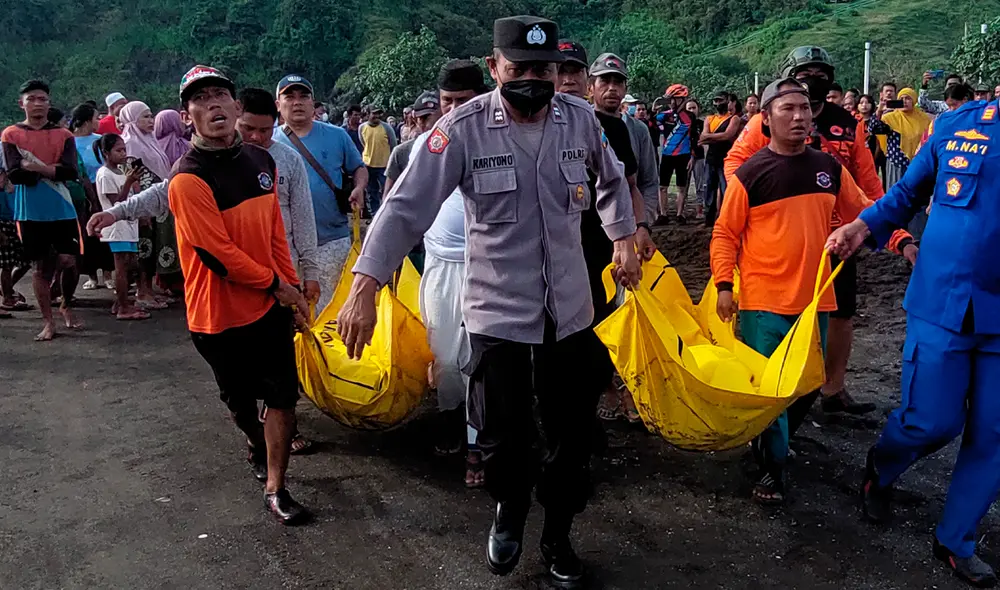 Miembros indonesios de un equipo de búsqueda y rescate evacúan cadáveres durante una operación de búsqueda luego de un accidentado ritual en la playa. Foto: AFP