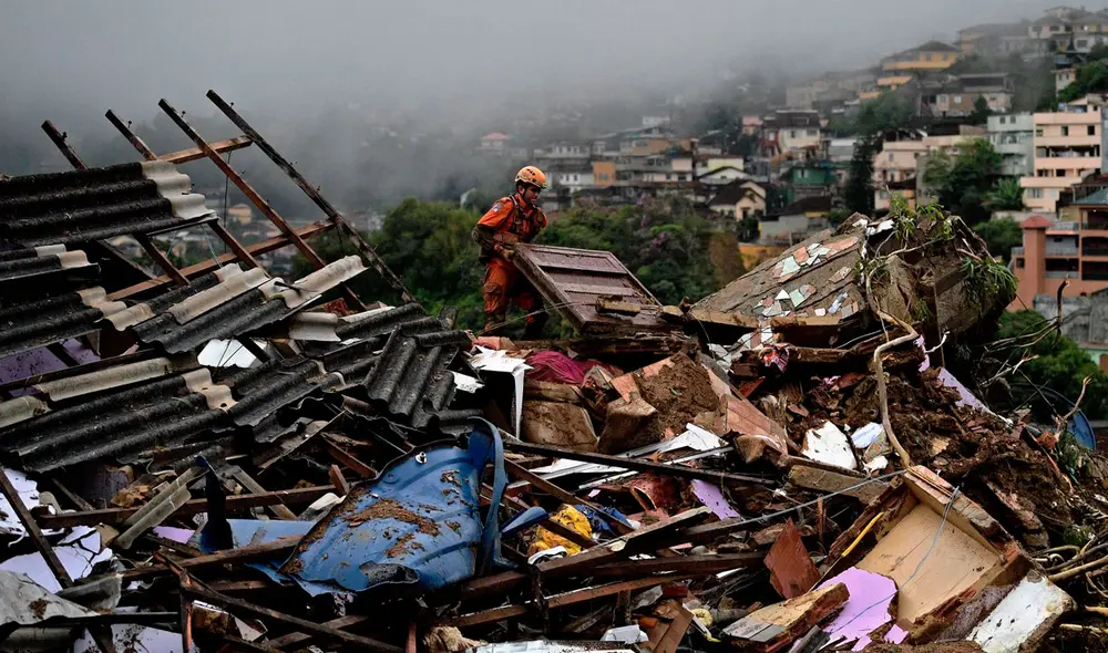 Un miembro de equipo de rescate de los servicios de bomberos levanta escombros para buscar sobrevivientes después de un deslizamiento de tierra en Petrópolis, Brasil. Foto: AFP Un miembro de equipo de rescate de los servicios de bomberos levanta escombros para buscar sobrevivientes después de un deslizamiento de tierra en Petrópolis, Brasil. Foto: AFP