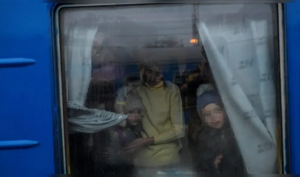 Niños se despiden de su padre frente a un tren de evacuación en la estación central de trenes de Odessa. Foto: referencial/AFP