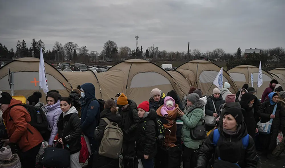 Un grupo de refugiados espera ser transportado después de cruzar la frontera entre Ucrania y Polonia en el cruce fronterizo de Medyka. Foto: AFP Un grupo de refugiados espera ser transportado después de cruzar la frontera entre Ucrania y Polonia en el cruce fronterizo de Medyka. Foto: AFP