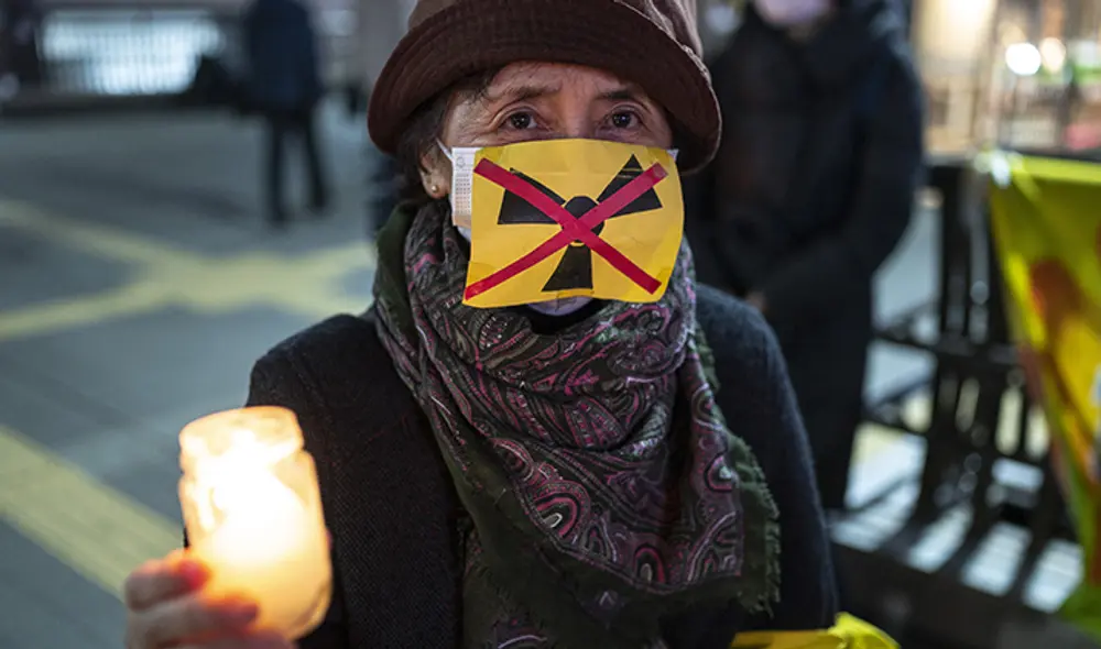Un grupo de personas participó en una vigilia con velas en memoria de las víctimas del terremoto y el tsunami en Mitaka, en las afueras de Tokio. Foto: AFP