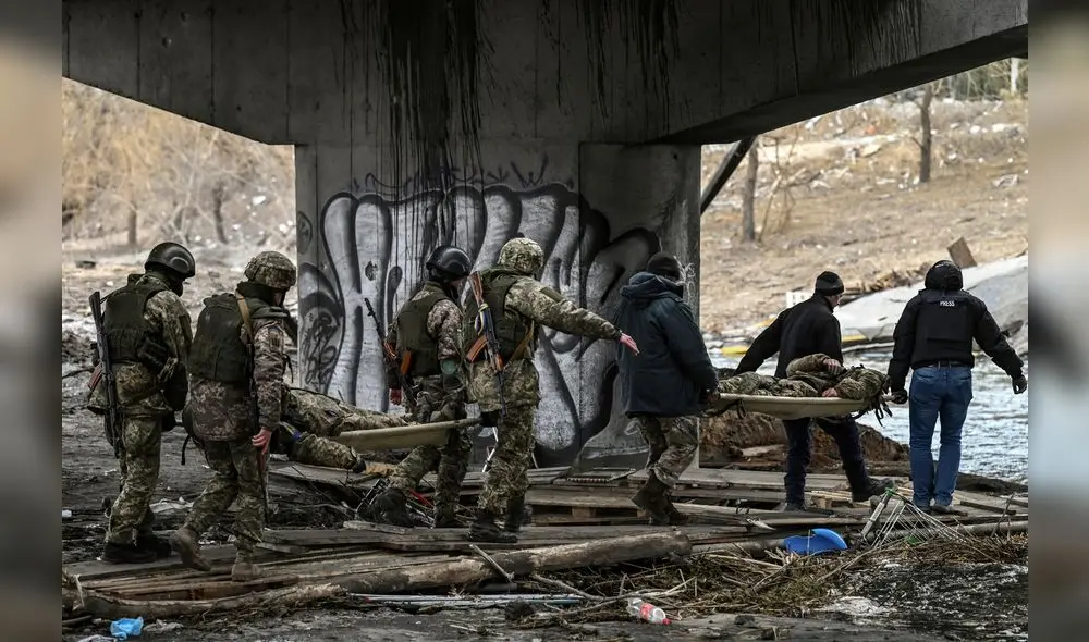 Militares ucranianos transportan el cuerpo de camaradas en camillas en la ciudad de Irpin, al noroeste de Kiev, el 13 de marzo de 2022. Foto: AFP Militares ucranianos transportan el cuerpo de camaradas en camillas en la ciudad de Irpin, al noroeste de Kiev, el 13 de marzo de 2022. Foto: AFP