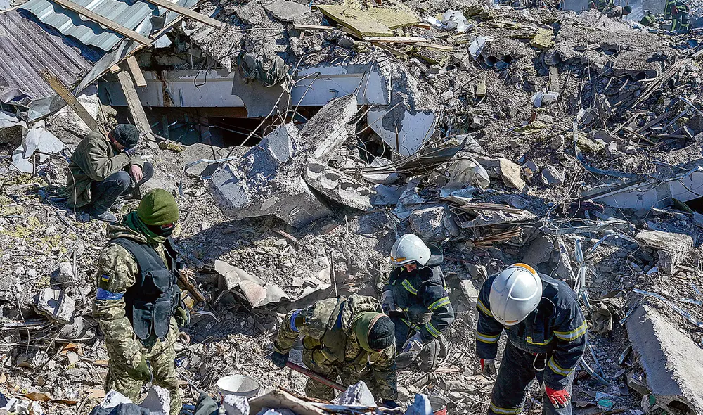 Escombros humanos. Soldados ucranianos y oficiales de rescate buscan cuerpos entre los escombros de la escuela militar alcanzada por cohetes rusos el día anterior en Mikolaiv. Foto: Agencia AFP