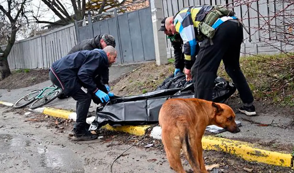 Trabajadores de servicios comunales recogen el cuerpo de un hombre muerto por bombardeos de tropas rusas en la ciudad de Bucha. Foto: AFP Trabajadores de servicios comunales recogen el cuerpo de un hombre muerto por bombardeos de tropas rusas en la ciudad de Bucha. Foto: AFP