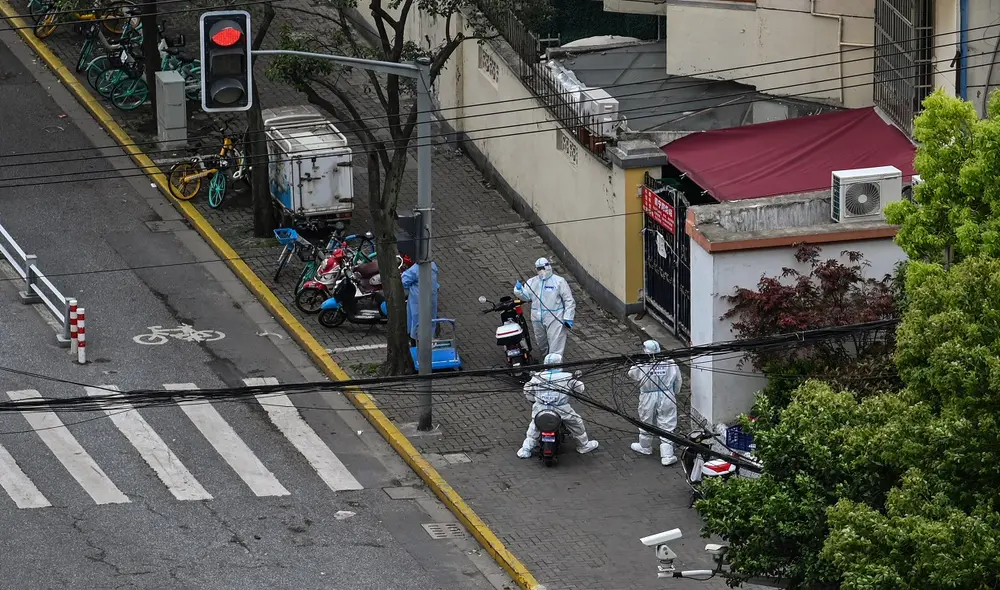 Policías se paran junto a la entrada de un vecindario durante un bloqueo de coronavirus en el distrito de Jing'an (Shanghái). Foto: AFP Policías se paran junto a la entrada de un vecindario durante un bloqueo de coronavirus en el distrito de Jing'an (Shanghái). Foto: AFP