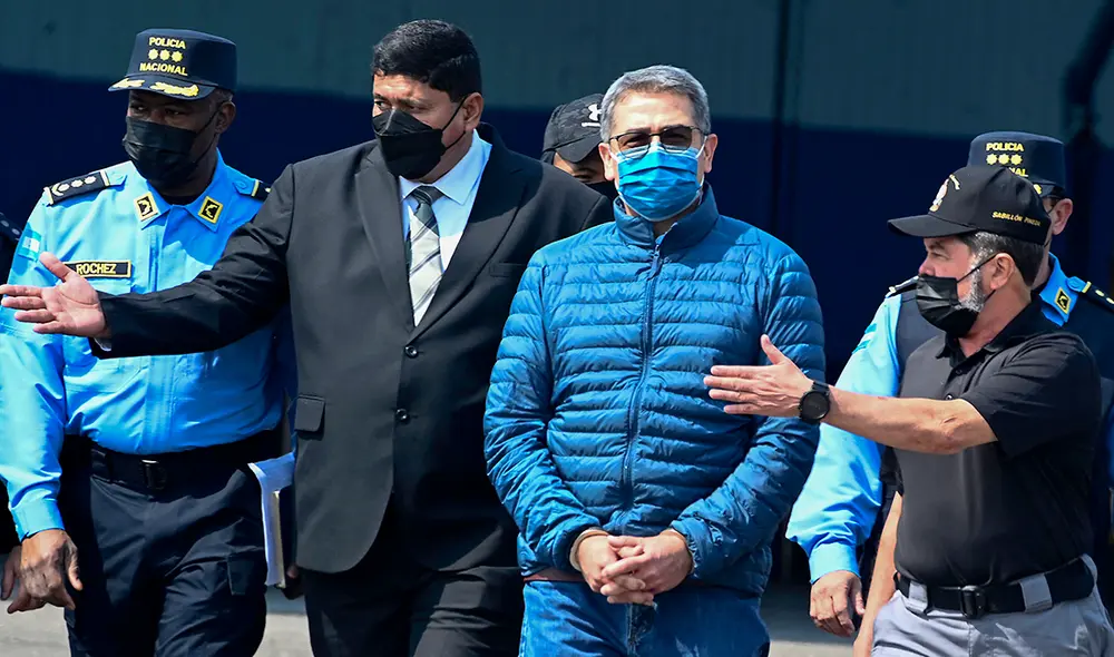 El expresidente de Honduras, Juan Orlando Hernández, es escoltado hacia un avión de la DEA, durante su extraditación a Estados Unidos. Foto: AFP