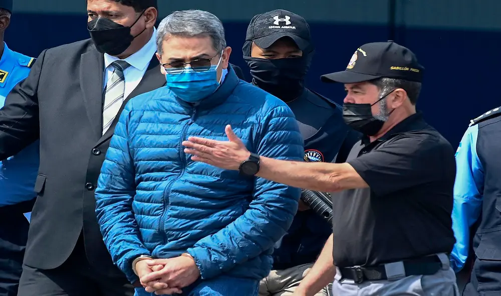 El expresidente de Honduras Juan Orlando Hernández es escoltado hacia un avión de la Agencia Antidrogas de EE. UU. (DEA). Foto: AFP