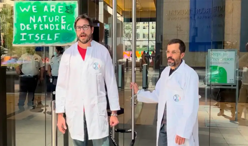 Científicos Peter Kalmus y Eric Gill encadenados en la puerta del banco Chase de Los Ángeles. Foto: Captura video
