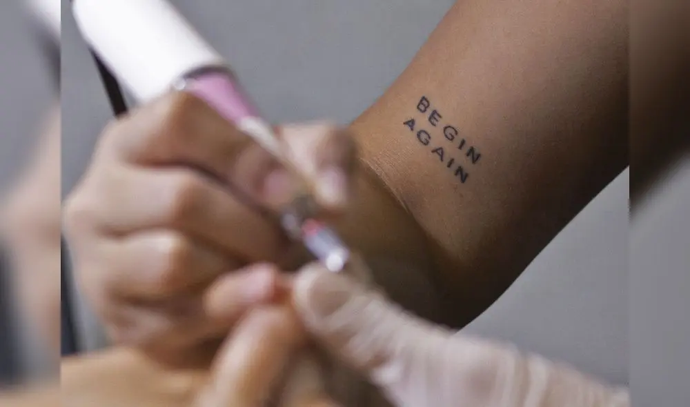 Tatuaje en el brazo de la manicurista venezolana Yara González mientras trabaja en un salón de belleza en Caracas, el 17 de enero de 2022. Foto: AFP