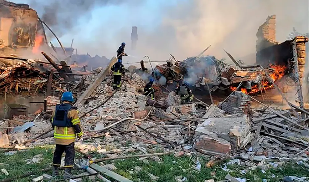 Esta fotografía muestra a los bomberos ucranianos apagando un incendio después de que misiles rusos alcanzaran una escuela en la región de Lugansk, en el este de Ucrania. Foto: AFP