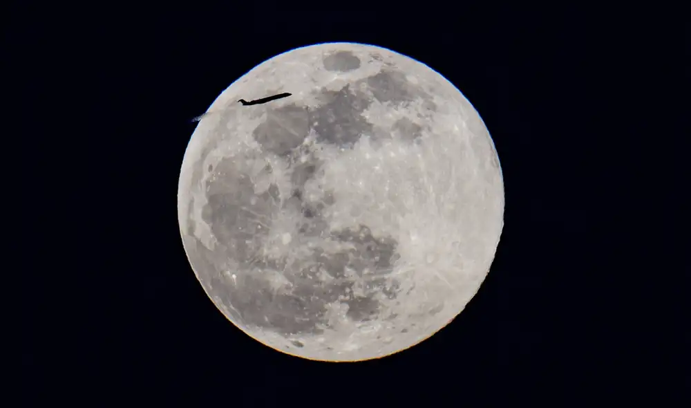 Un avión se ve cruzar al frente una superluna en Nueva York, Estados Unidos. Foto: AFP/ Angela Weiss