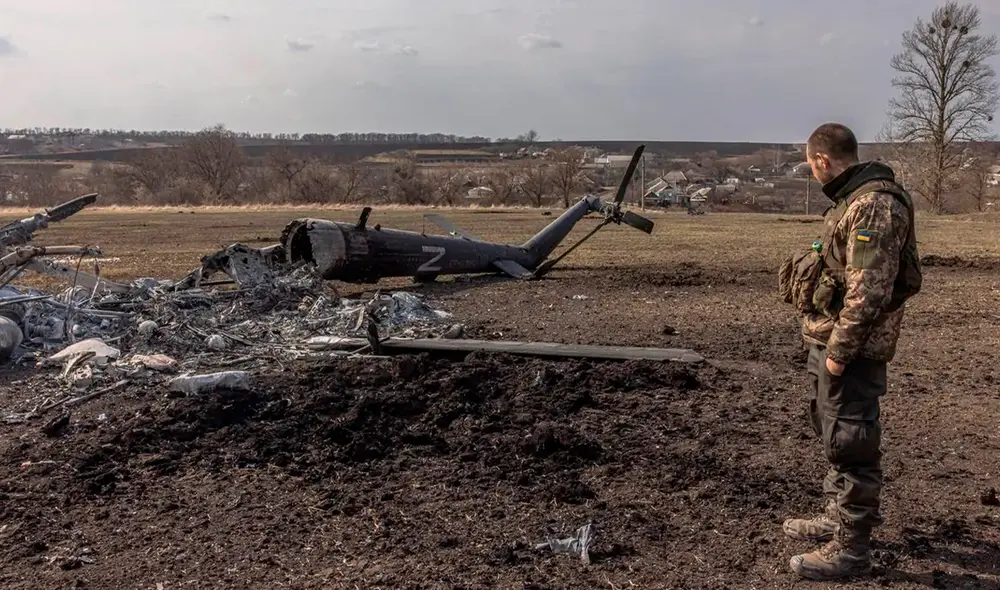 Soldado ucraniano frente a un helicóptero ruso destruido. Foto: EFE Soldado ucraniano frente a un helicóptero ruso destruido. Foto: EFE