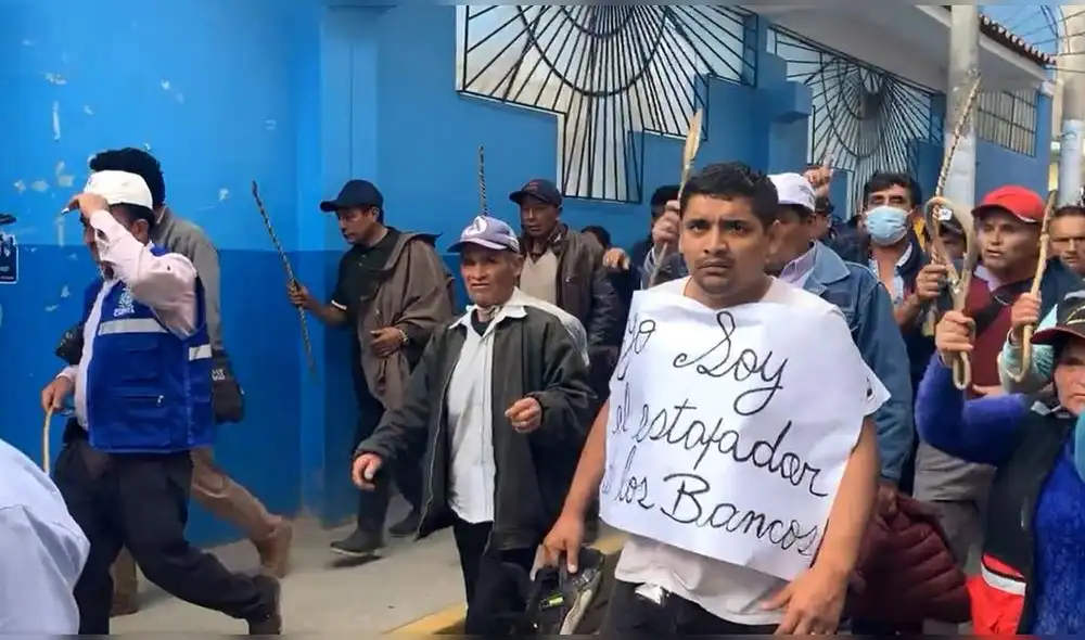 El imputado de robo, cargando un cartel que decía "Yo soy el estafador de bancos", caminó hasta la plaza de armas de Chota. Crédito: captura de vídeo/Telesystem Noticias.