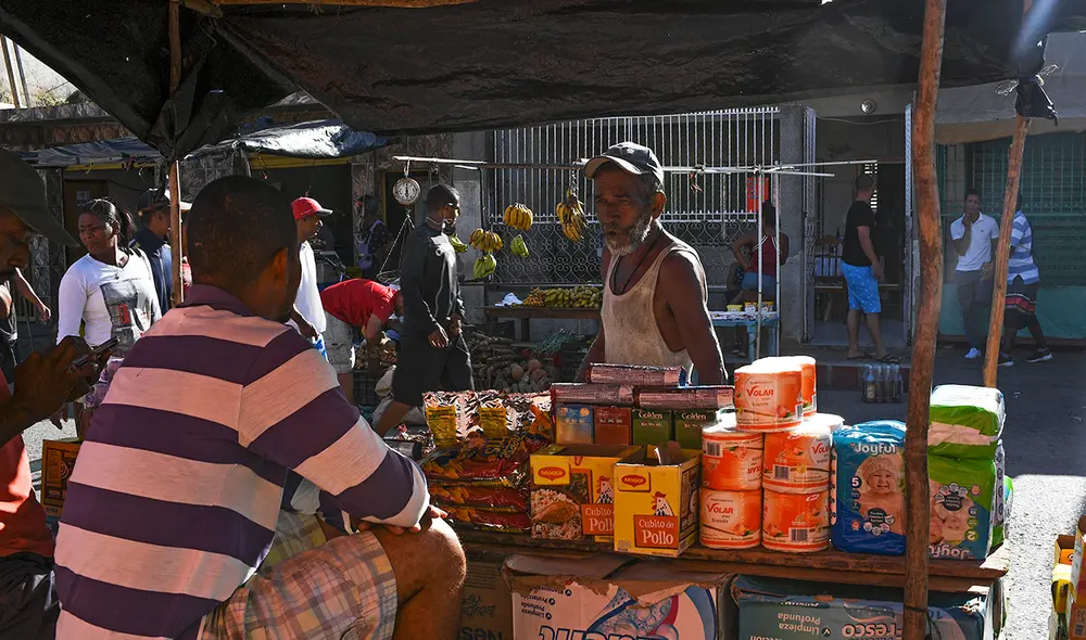 Un comerciante venezolano espera clientes mientras vende diferentes productos de la canasta básica familiar en el mercado callejero de Guiria. Foto: AFP Un comerciante venezolano espera clientes mientras vende diferentes productos de la canasta básica familiar en el mercado callejero de Guiria. Foto: AFP